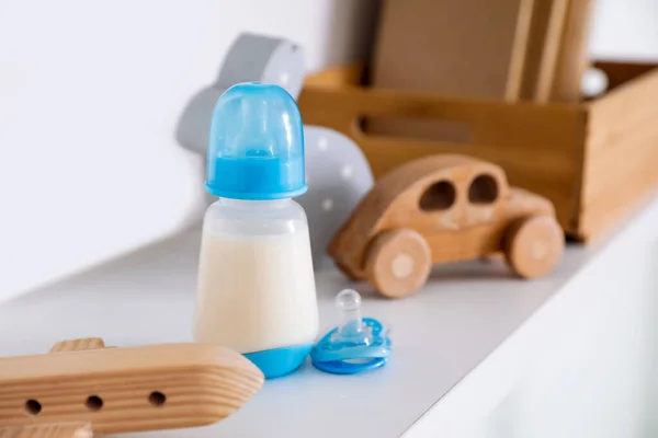Botella Leche Para Bebé Con Juguetes Estante Primer Plano — Foto de Stock