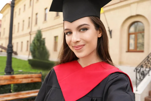 Female student in bachelor robe on her graduation day