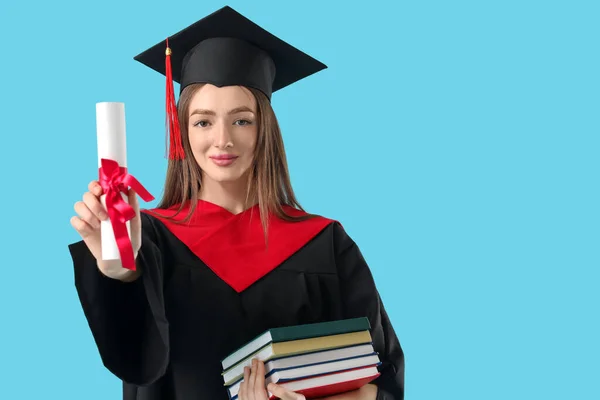卒業証書と色の背景の本を持つ女性卒業生 — ストック写真