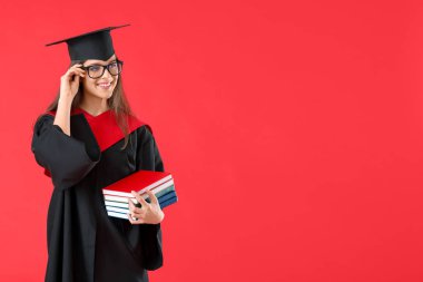 Renkli arka plan kitapları olan mezun bir bayan öğrenci.