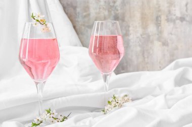 Lezzetli bardaklar ve açık arkaplanda çiçek açan dallar.