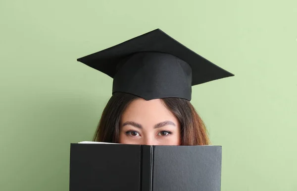 女性卒業生とともに本の色の背景 — ストック写真