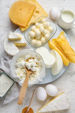 Farklı süt ürünleri ve arka planda tavuk yumurtaları.