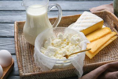 Koyu ahşap arka planda farklı süt ürünleri içeren tepsi, yakın plan