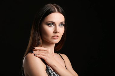 Siyah arka planda güzel manikürlü genç bir kadın.