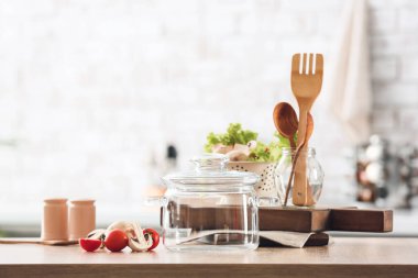 Mutfaktaki masada taze sebzeler ve tencere var.