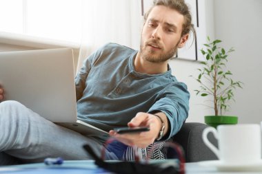 Evde çalışan yakışıklı genç adam.