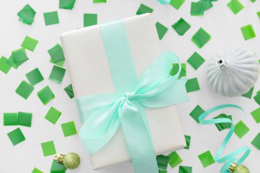 Noel dekorlu hediye kutusu ve beyaz arka planda konfeti.