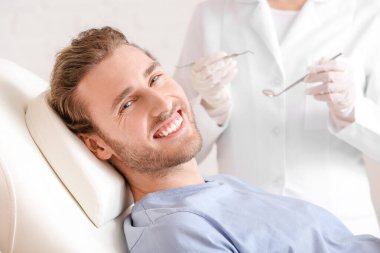 Klinikteki dişçiyi ziyaret eden genç adam, yakın plan.