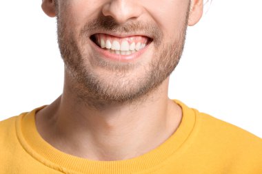 Beyaz arka planda gülümseyen genç adam, yakın plan