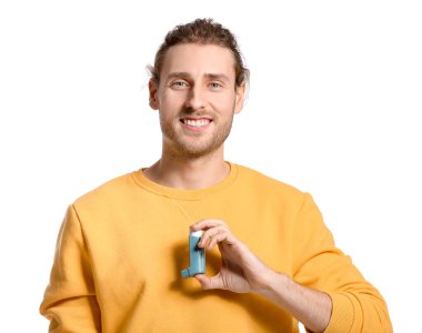 Beyaz arka planda astım spreyi olan genç bir adam.