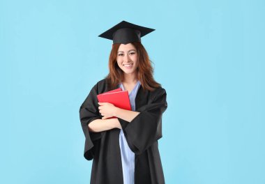 Renkli arka plan kitapları olan mezun bir bayan öğrenci.