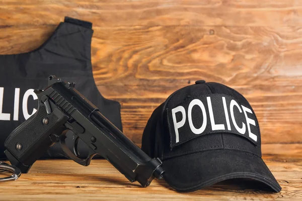 Uniforme Policial Com Arma Fundo Madeira — Fotografia de Stock