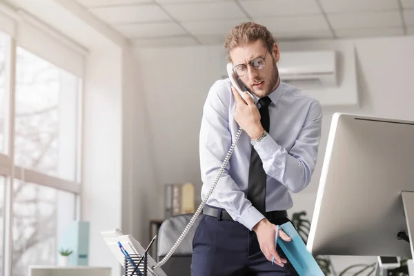 若い男がオフィスで電話で話している — ストック写真