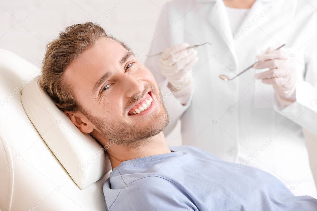 Young man visiting dentist in clinic, closeup