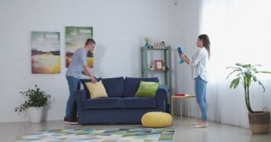 Oda işi yaparken dans eden mutlu genç çift.