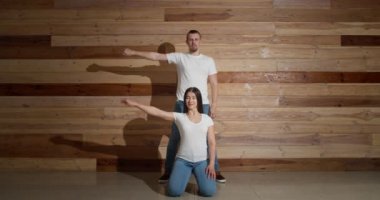 Tahta duvarın yanında birkaç genç dansçı.