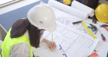 Ofiste çizimlerle çalışan kadın mühendis.