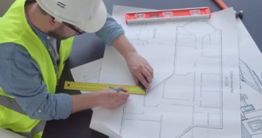 Ofiste çizimlerle çalışan erkek mühendis