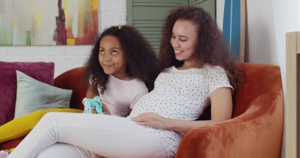 Jonge Zwangere Afro Amerikaanse Vrouw Haar Dochtertje Zitten Thuis Bank — Stockvideo