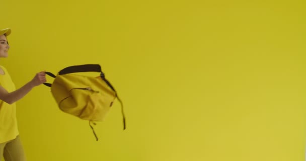 Sarı Arka Planda Sırt Çantalı Genç Bir Kadın — Stok video
