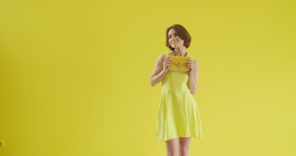 Elegante Mujer Joven Con Bolso Sobre Fondo Amarillo — Vídeo de stock