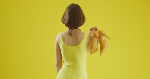 Mujer Joven Con Tacones Altos Con Estilo Sobre Fondo Amarillo — Vídeos de Stock