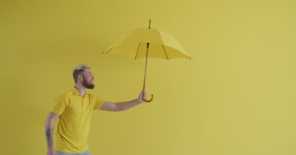Mladý Muž Ztrácí Svůj Žlutý Deštník Bouřlivém Počasí Barevném Pozadí — Stock video