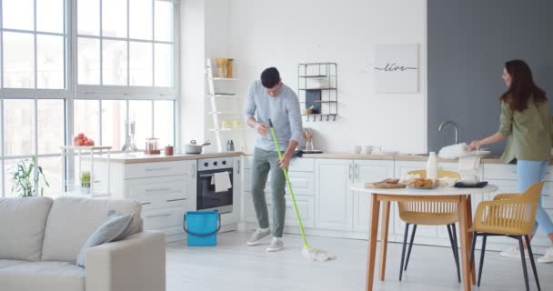 Giovane Coppia Divertirsi Durante Pulizia Della Cucina — Video Stock