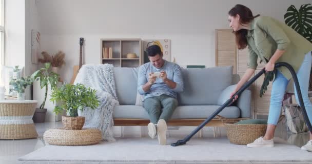 Junge Frau Staubt Teppich Während Ihr Mann Hause Mit Dem — Stockvideo