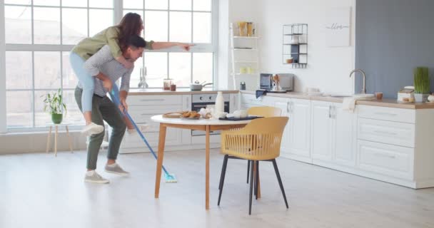 台所を掃除しながら楽しい時間を過ごしている若いカップル — ストック動画