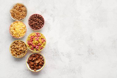 Arka planda farklı mısır gevrekleri olan kaseler