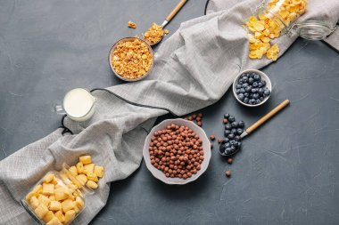 Farklı mısır gevreği, böğürtlen ve sütlü kompozisyon koyu arka planda