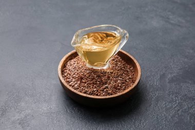 Keten yağlı sos teknesi ve koyu arkaplanda tohumlar.