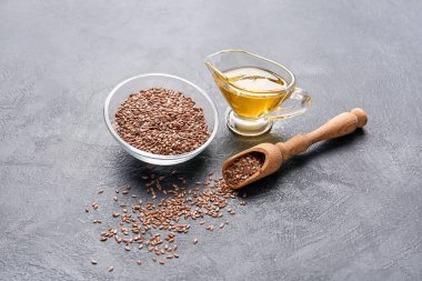 Keten yağlı sos teknesi ve koyu arkaplanda tohumlar.