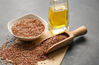 Koyu arka planda keten tohumu ile kase ve kepçe, yakın plan