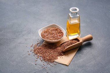 Keten yağlı bir şişe ve koyu arkaplanda tohumlar