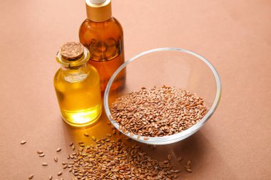 Renkli arka planda keten tohumu ve yağlı kase, yakın plan