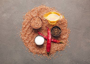 Esmer arka planda keten tohumları, yağ ve baharatlarla kompozisyon