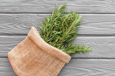 Ahşap arka planda taze biberiyeli çanta.