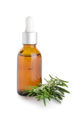 Bir şişe temel yağ ve beyaz arka planda taze biberiye.