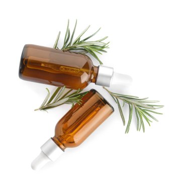 Önemli yağ şişeleri ve beyaz arka planda taze biberiye.