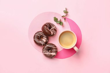 Renkli arka planda bir fincan kahve ve donutla kompozisyon