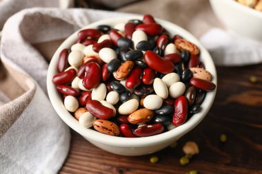 Ahşap arka planda farklı baklagiller olan bowling, yakın plan.