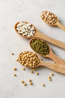 Işık arkaplanda farklı baklagillere sahip kaşıklar