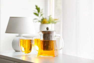 Çaydanlık ve bardaklar masadaki sıcak içecek.