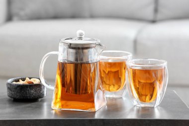 Çaydanlık ve bardaklar masadaki sıcak içecek.