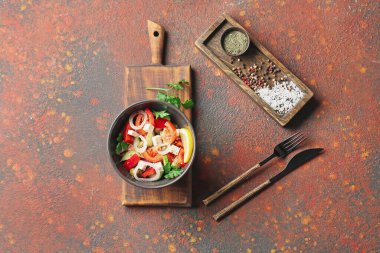 Arka planda bir kase lezzetli Yunan salatası.