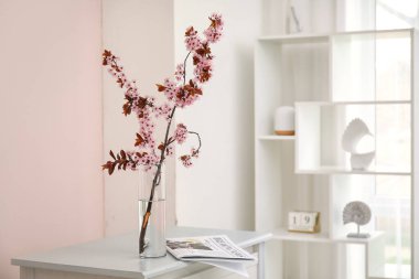 Odada çiçek açan güzel dalları olan vazolar.