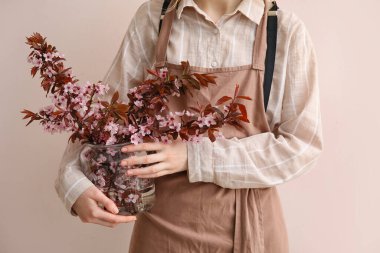 Renkli arka planda çiçek açan dalları olan güzel bir kadın.